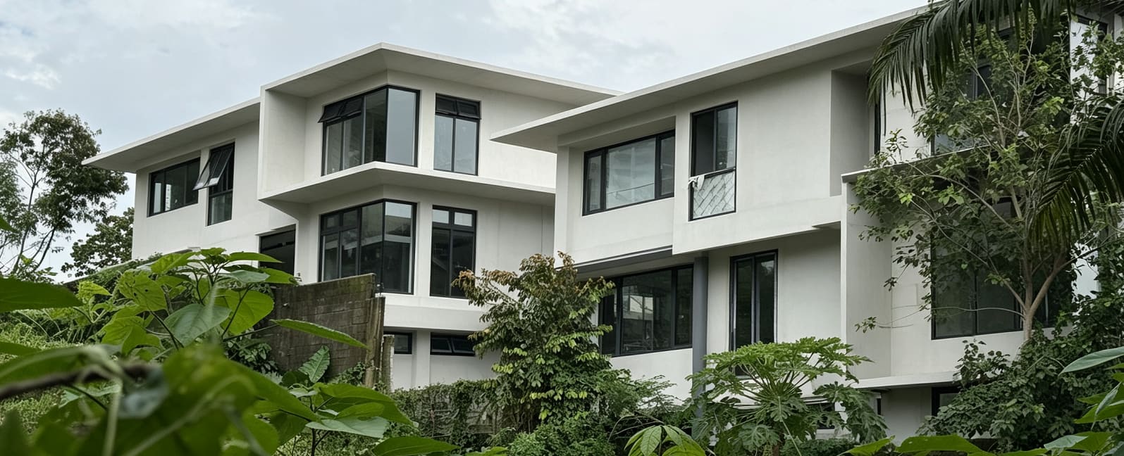 Completed white three-storey villa seen from the street